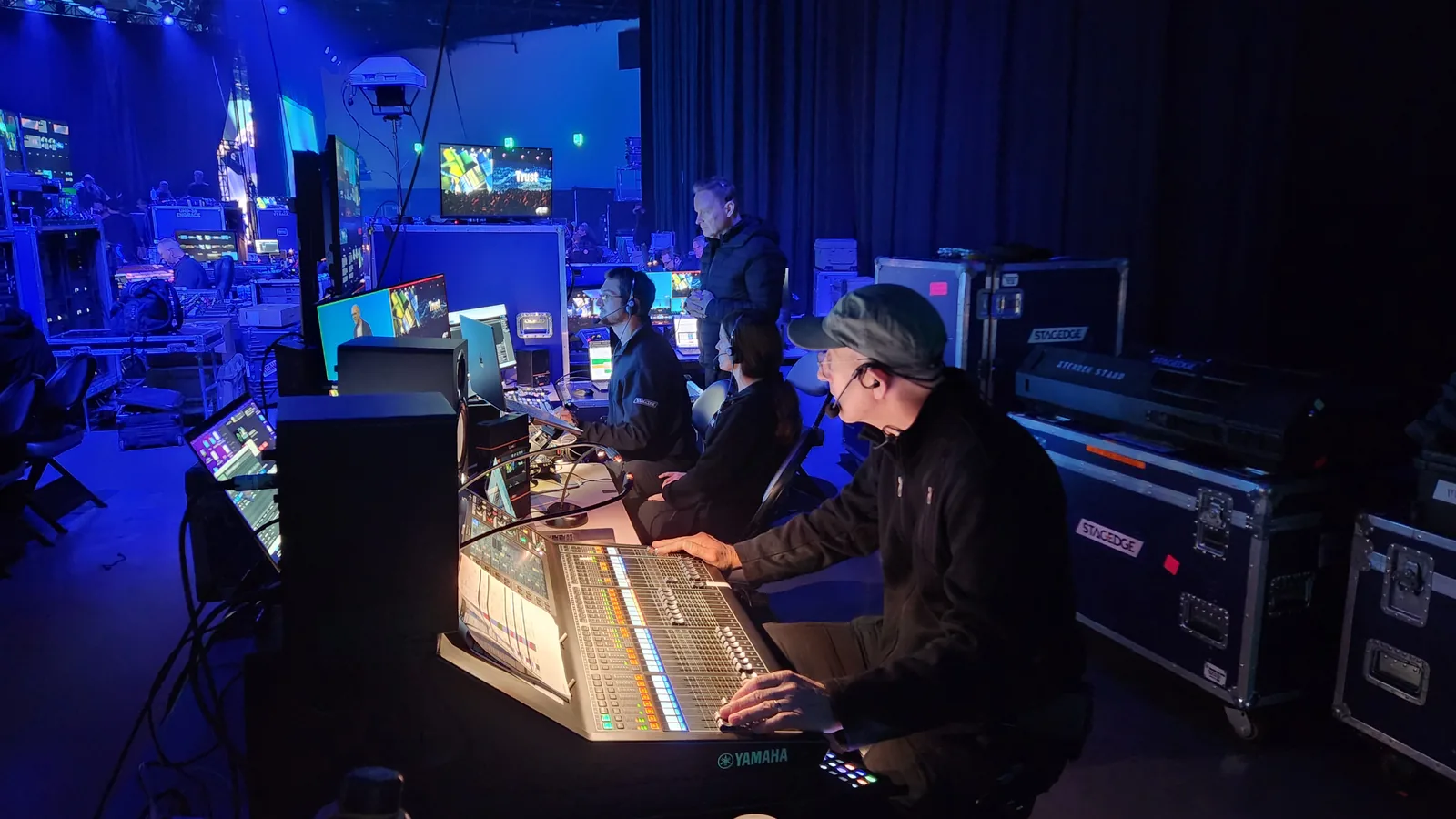 Production crew working at front of house consoles and multiviewers during a live event