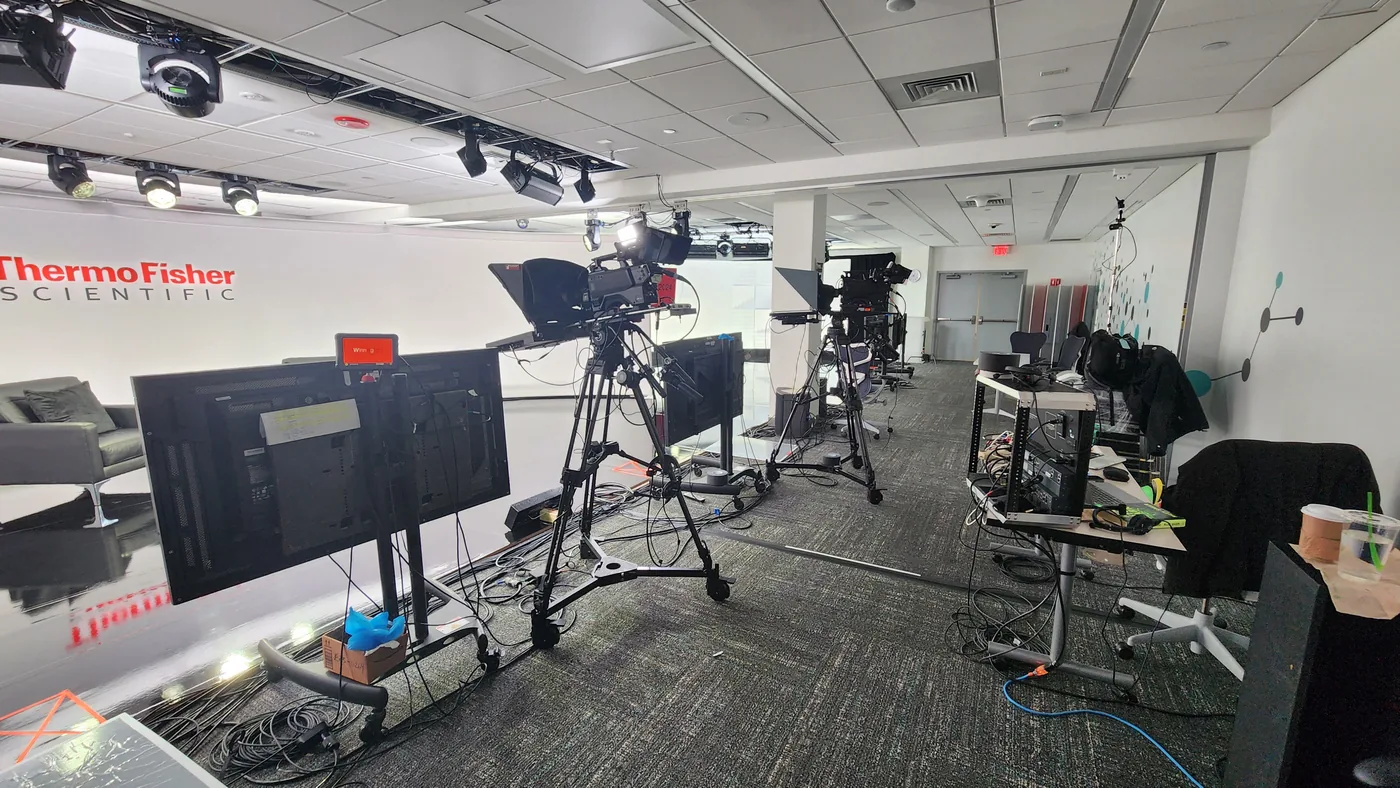 Broadcast cameras, teleprompters, and monitors set up for a shoot inside a corporate office space
